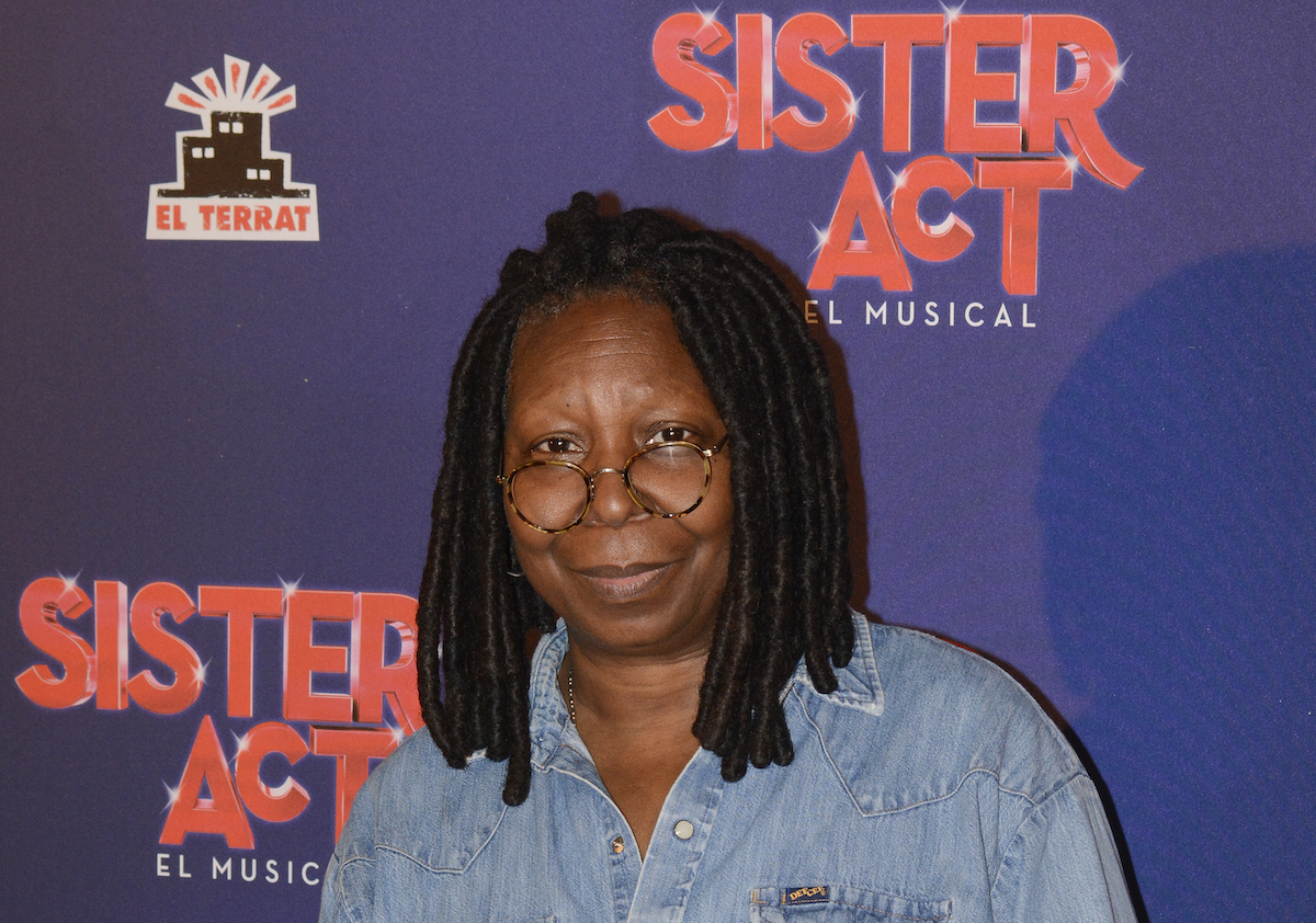 Whoopi Goldberg porte un denim et pose devant le logo 'Sister Act: The Musical'