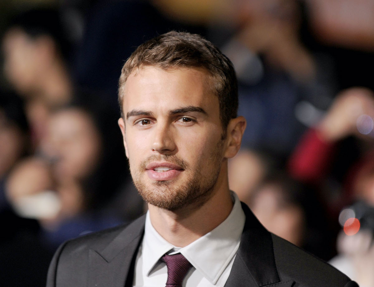 Theo James regarde la caméra alors qu'il arrive à la première de Divergente