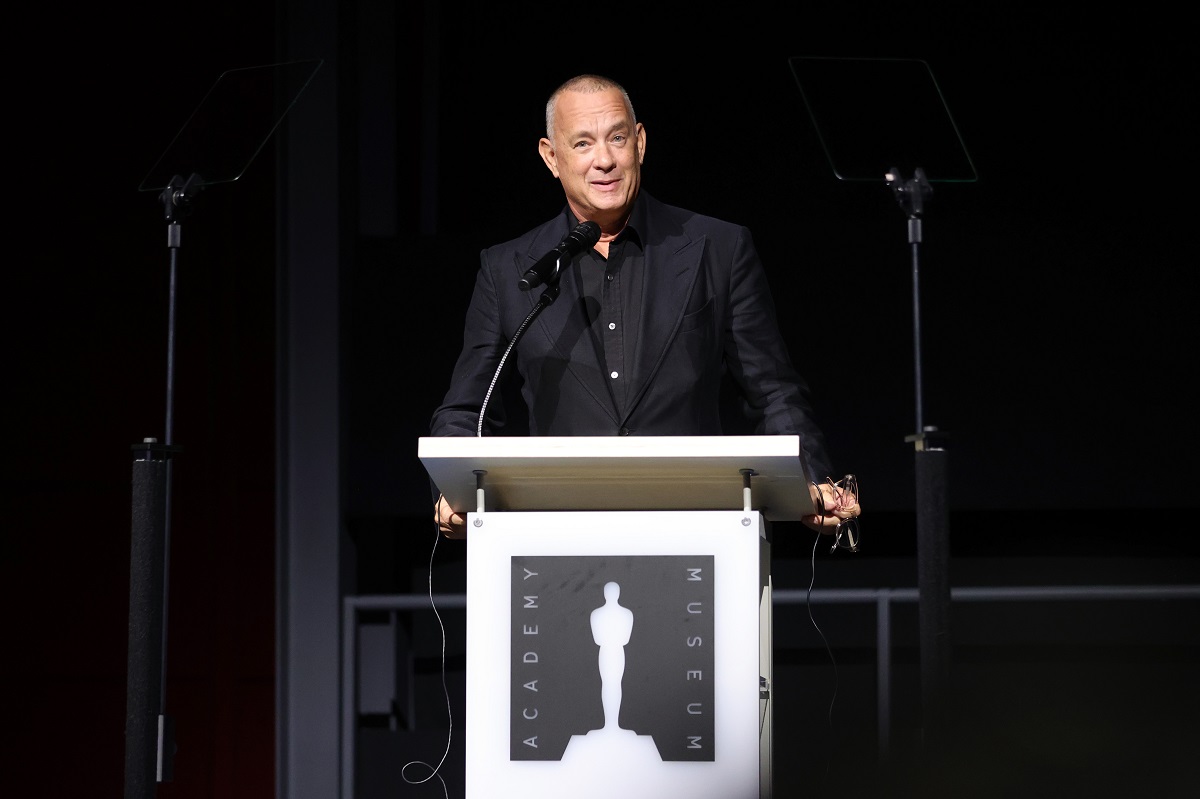 Tom Hanks souriant en parlant sur scène.