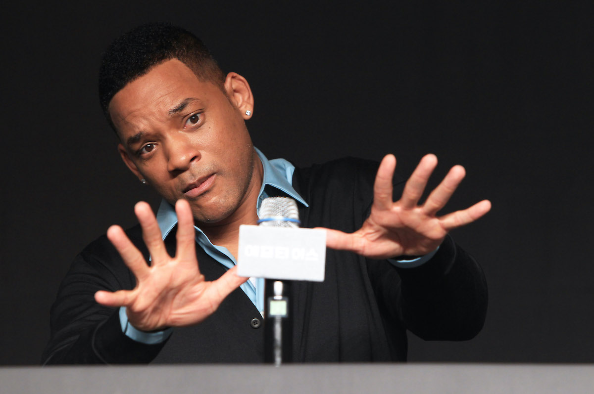 Will Smith tient ses mains devant lui alors qu'il parle au micro