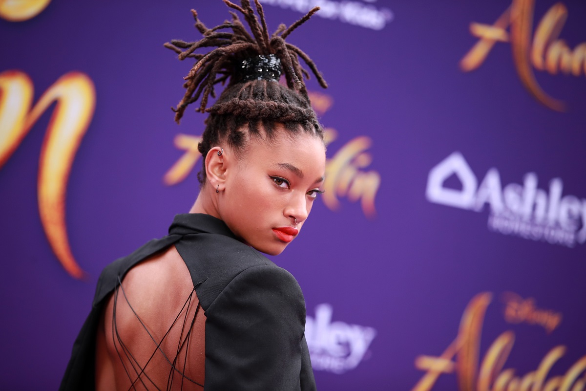 Willow Smith posant en portant une robe noire.