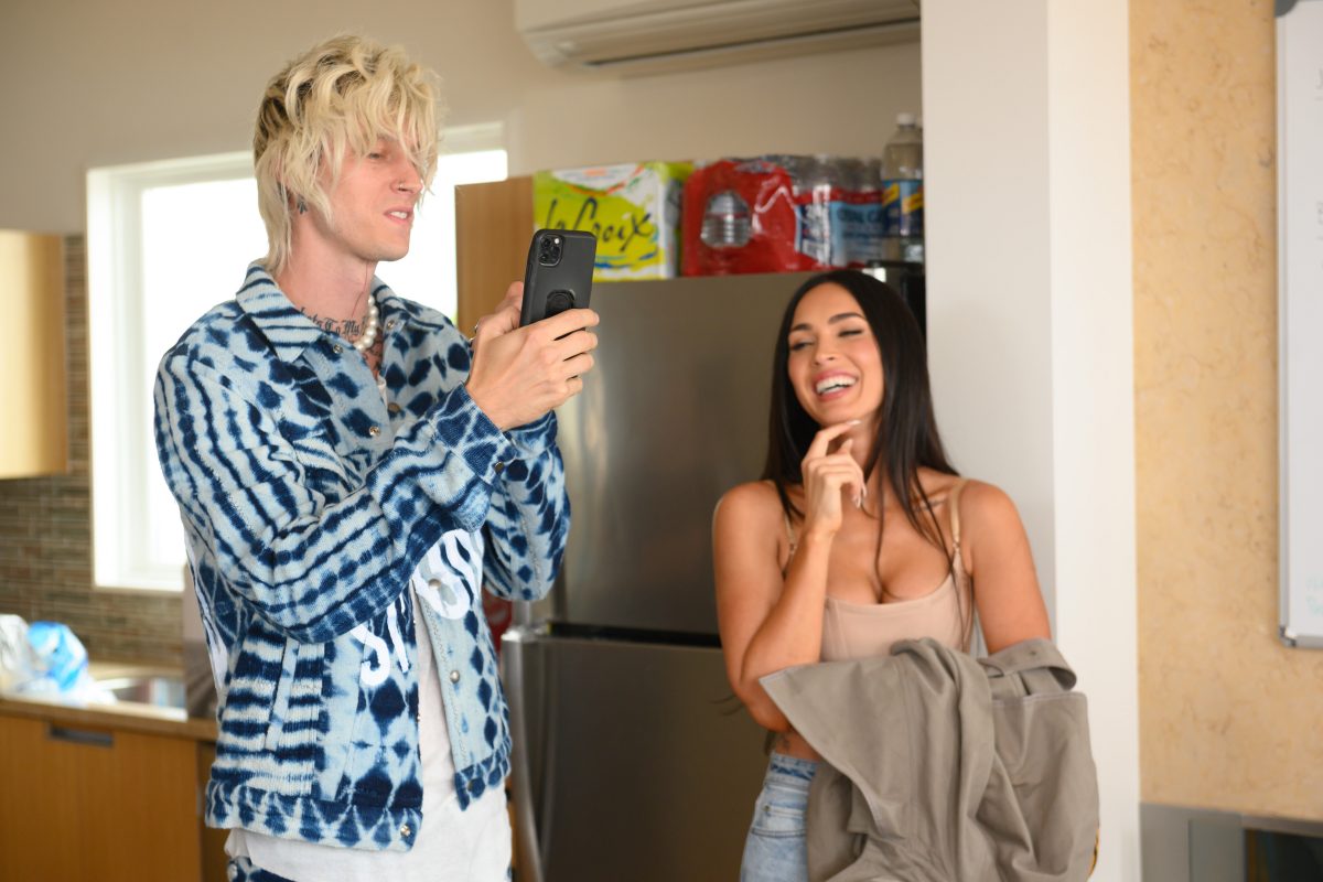 Photo de Machine Gun Kelly tenant son téléphone portable à côté de Megan Fox qui rit