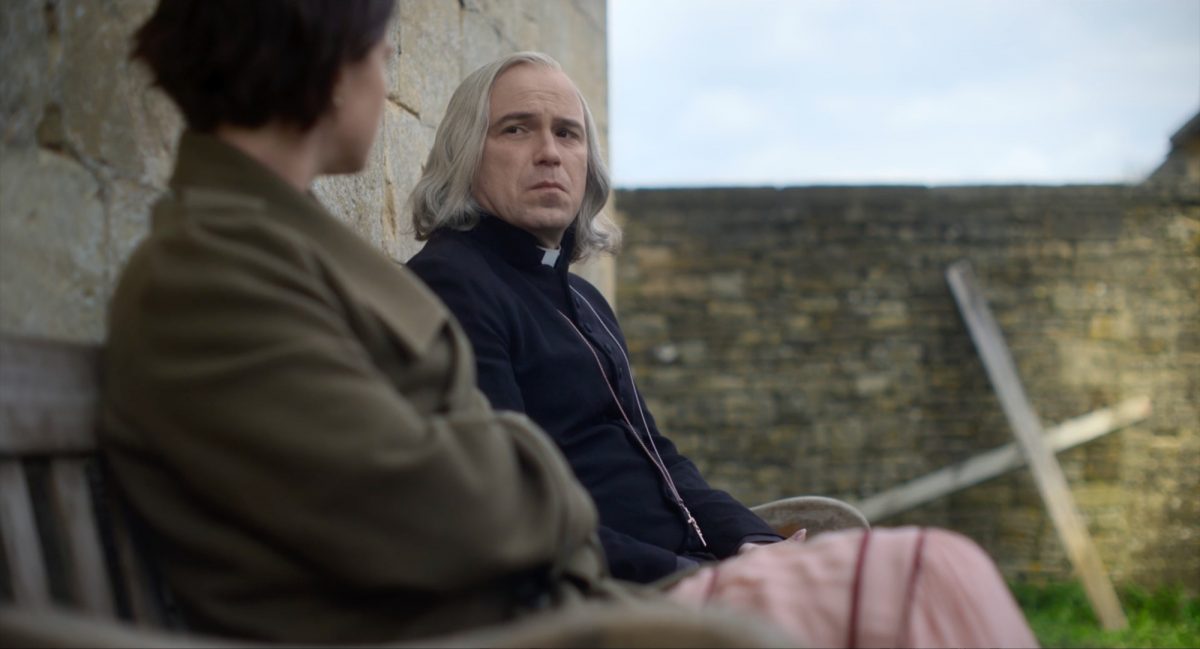 Jessie Buckley en tant que Harper et Rory Kinnear en tant que prêtre dans 'Men' assis sur un banc se regardant