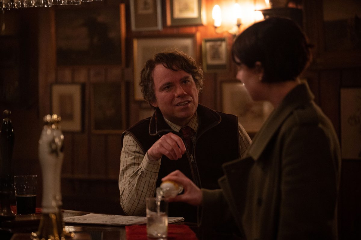 Rory Kinnear comme Geoffrey et Jessie Buckley comme Harper dans 'Men' assis au bar dans un pub se regardant