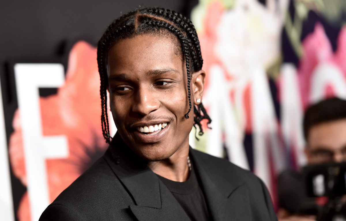 A$AP Rocky sourit en portant un costume lors d'un événement