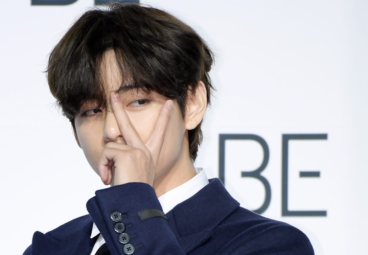 V de BTS brandit le signe de la paix lors de la conférence de presse du groupe pour 'BE'