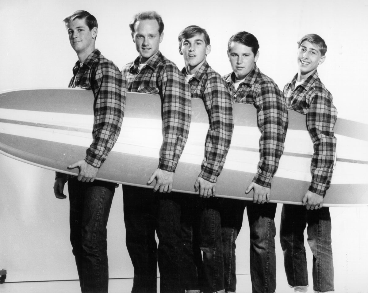 Les Beach Boys tenant une planche de surf