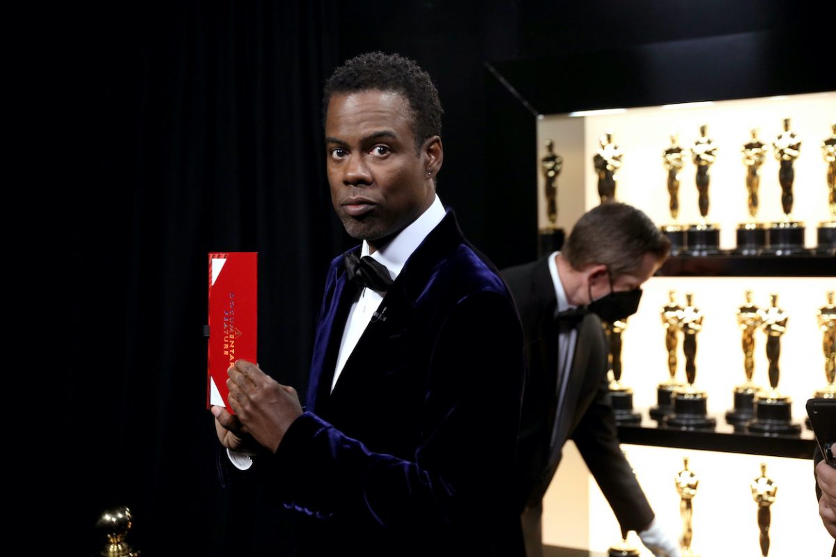 Chris Rock se tient dans les coulisses à côté des statuettes des Oscars aux Oscars 2022.  Rock hébergeant les Oscars 2023 est une rumeur qui pue le désespoir.