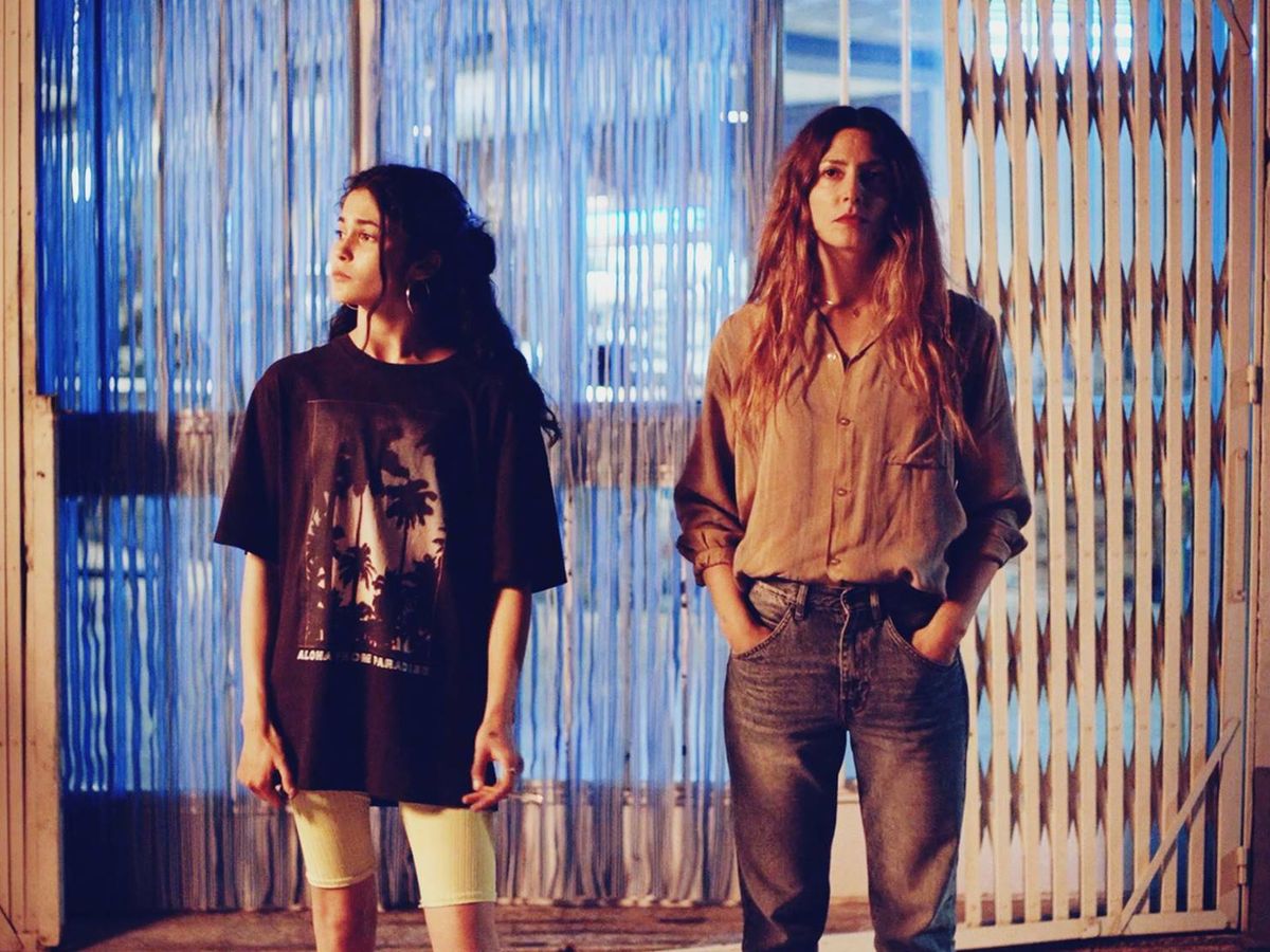 Luna Pamiés dans le rôle d'Ana et Barbara Lennie dans le rôle d'Isabella se tenant ensemble dans leur bar dans 'El Auga'