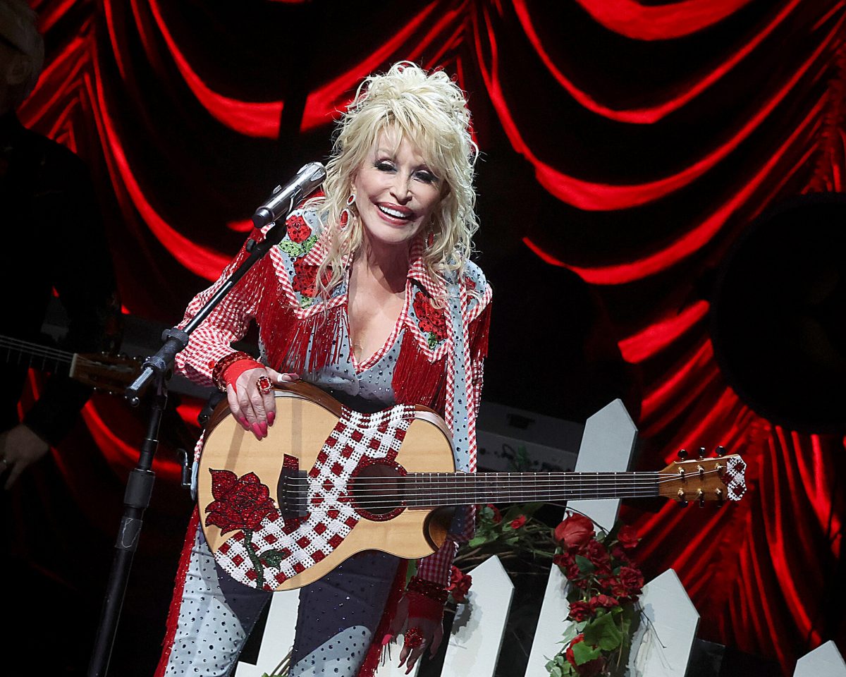 Dolly Parton, nouvelle intronisée au Rock & Roll Hall of Fame, se produisant sur scène avec une guitare à la main.