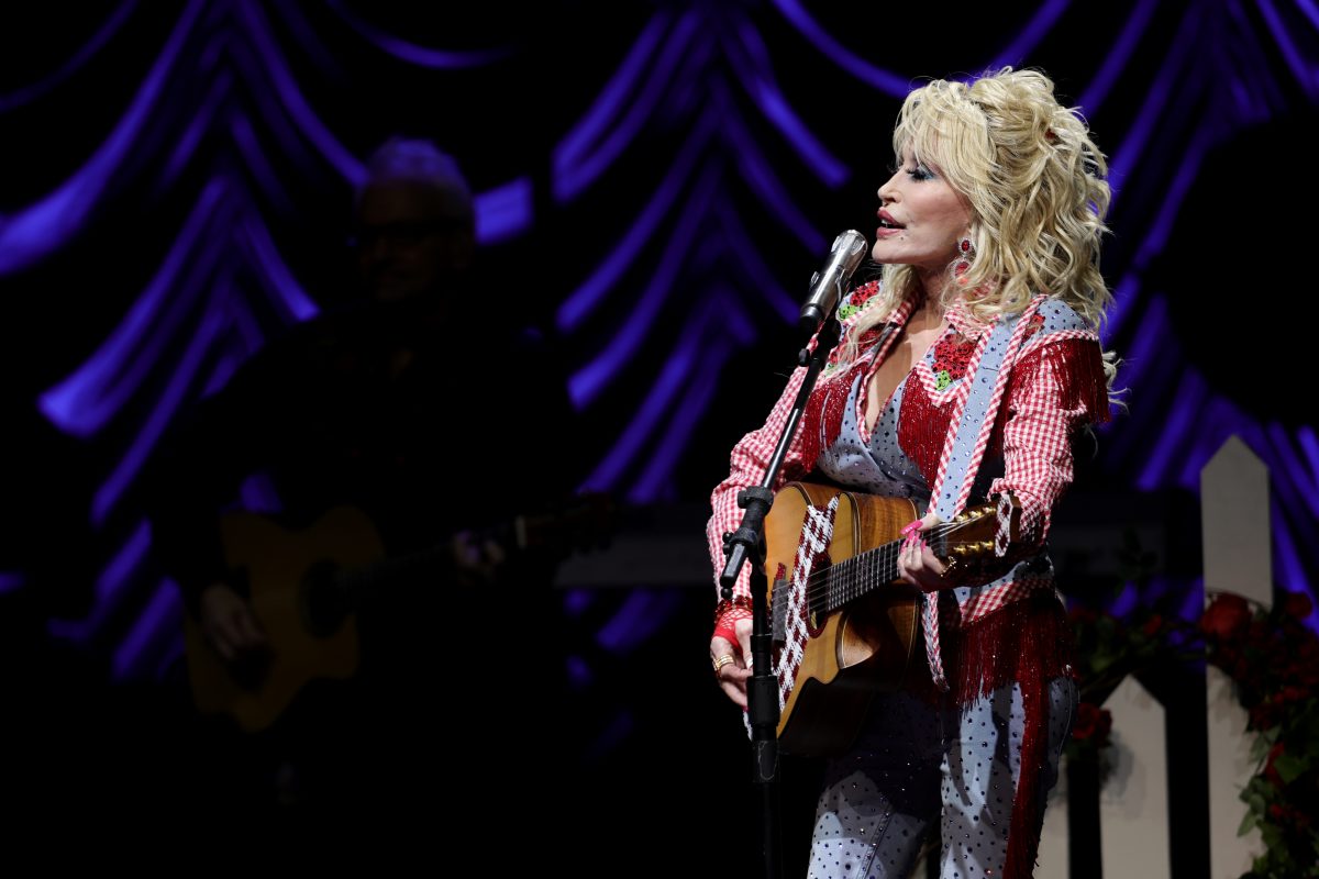 Dolly Parton, qui vient d'être intronisée au Rock & Roll Hall of Fame, chante sur scène et joue de la guitare.