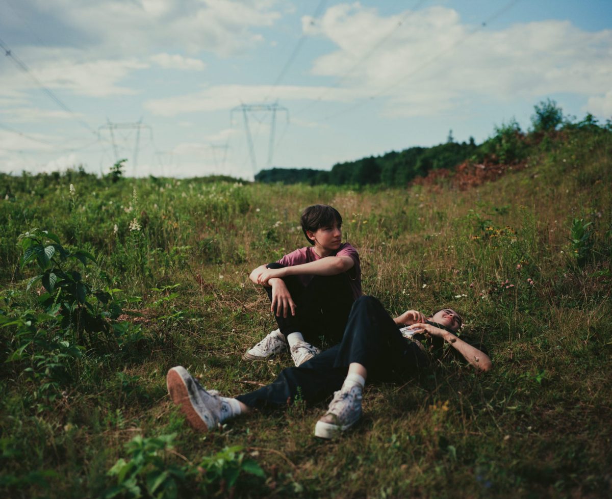 Joseph Engal comme Bastien et Sara Montpetit comme Chloé allongé sur l'herbe 'Falcon Lake'