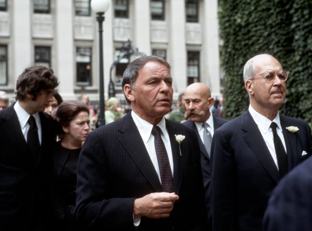 Frank Sinatra porte un costume et entre dans une église ; sa religion était le catholicisme.