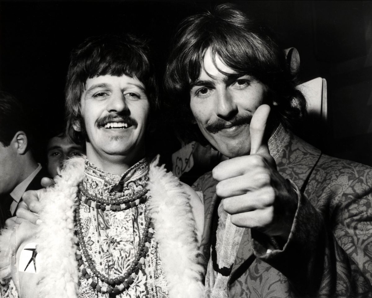 Ringo Starr des Beatles debout à côté de George Harrison pendant que ce dernier lève le pouce