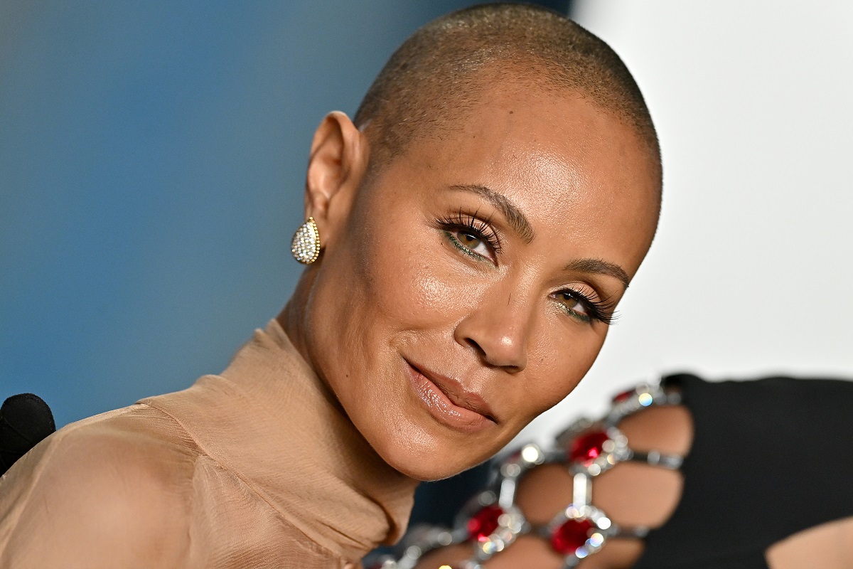 Jada Pinkett Smith sourit en portant une robe dorée.