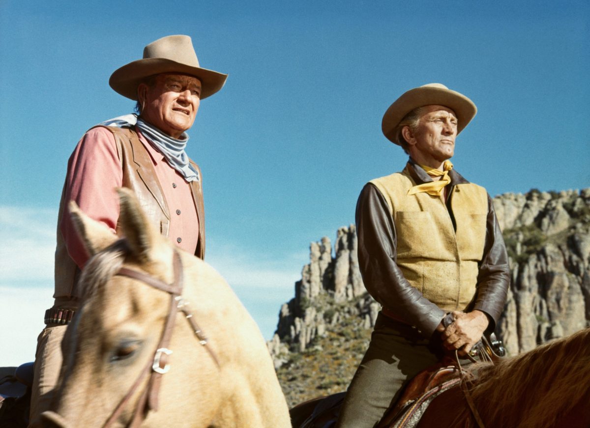 John Wayne comme Taw Jackson et Kirk Douglas comme Lomax dans 'The War Wagon' assis à cheval dans des uniformes de cow-boy