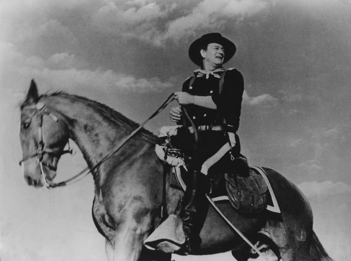 John Wayne dans sa performance en tant que colonel John Marlowe à cheval regardant par-dessus son épaule