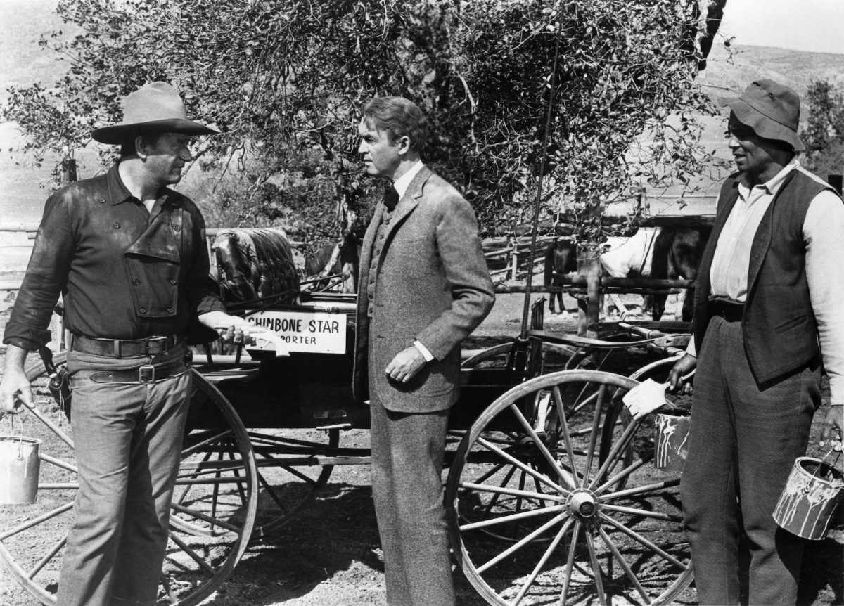 John Wayne, James Stewart et Woody Strode devant un chariot dans