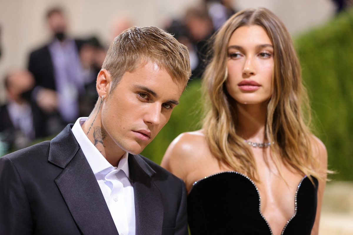 Justin Bieber portant un costume noir et debout à côté de Hailey Bieber, qui porte une tenue noire décolletée