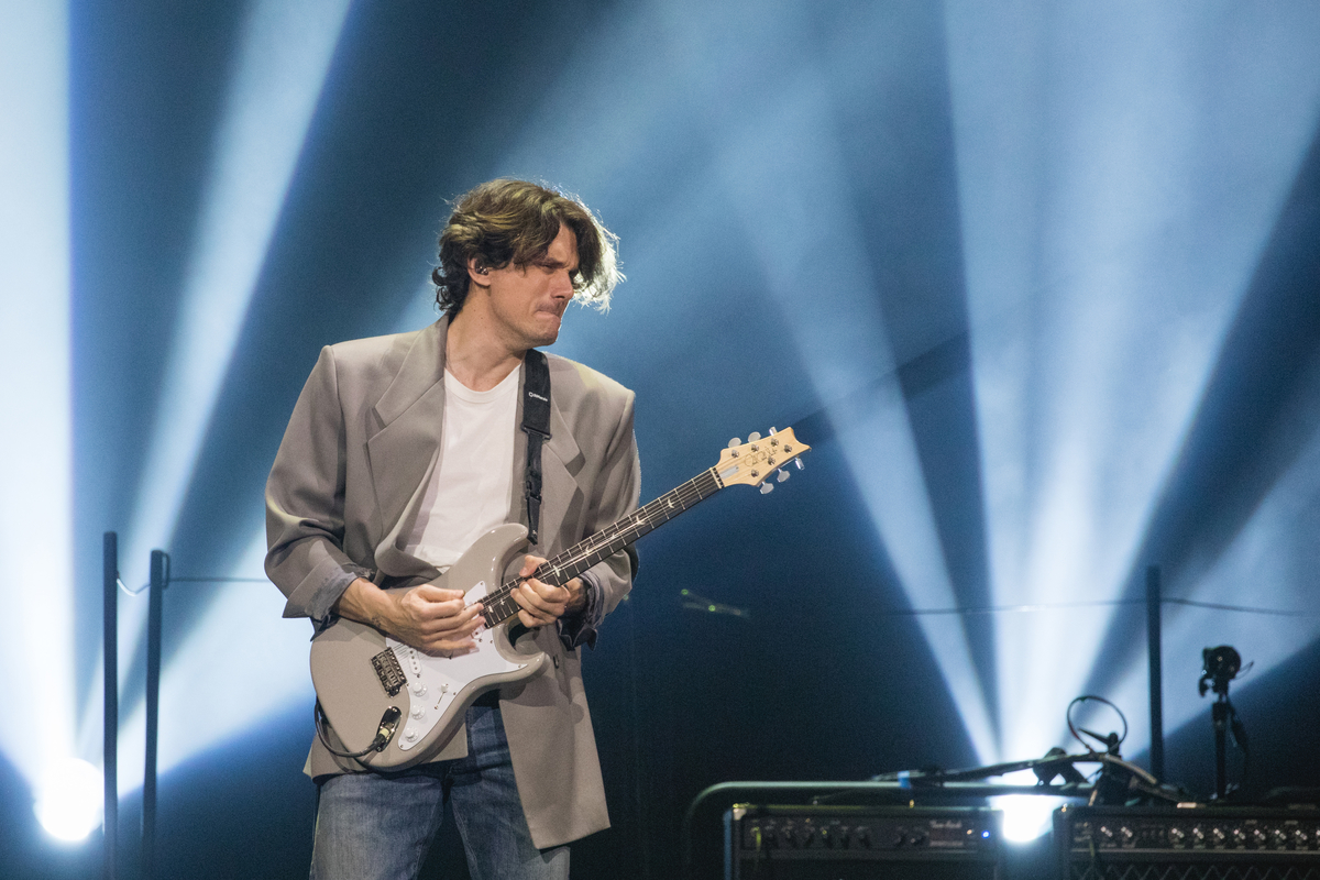 Vêtu d'un t-shirt blanc et d'un blazer gris, John Mayer se produit sur scène à Austin, au Texas.