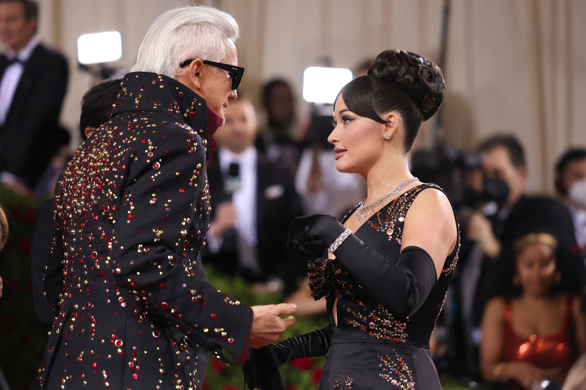Portant des tenues noires assorties, Baz Lurhmann et Kacey Musgraves parlent sur le tapis rouge du Met Gala à New York, NY.