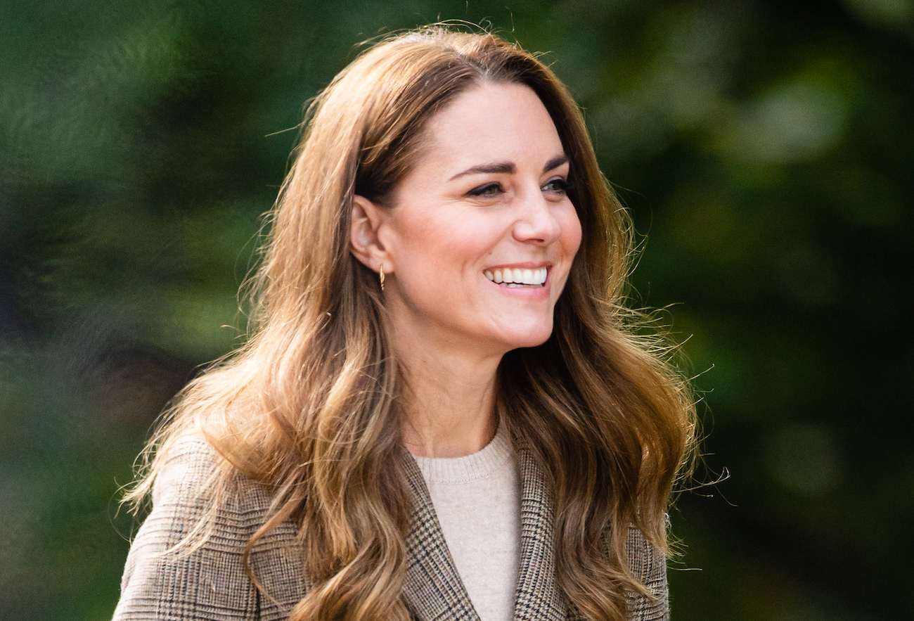 Kate Middleton portant une veste à carreaux et regardant vers le côté gauche de la photo