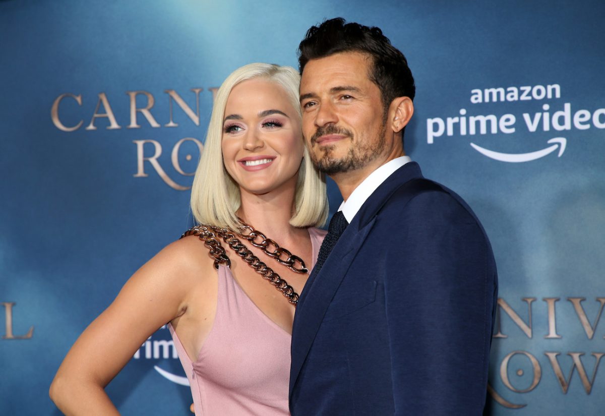 Katy Perry portant une tenue rose clair et debout à côté d'Orlando Bloom, qui porte une tenue sombre