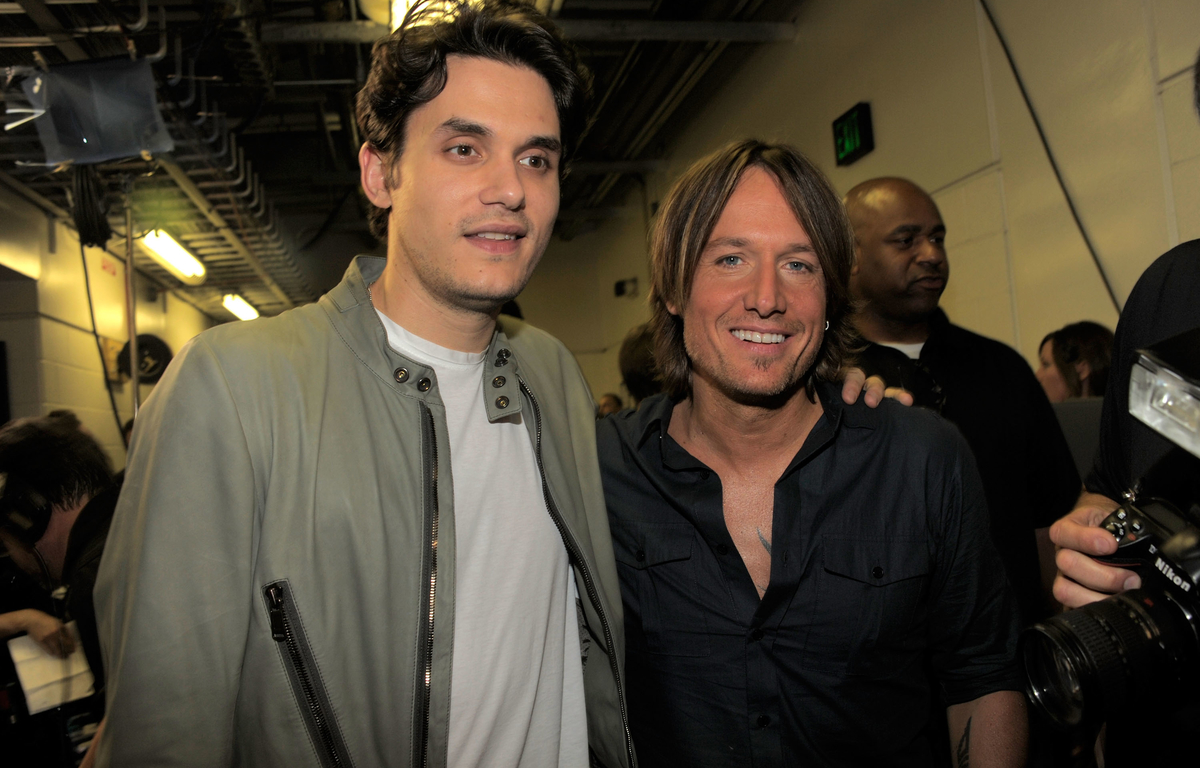 Keith Urban et John Mayer se tiennent l'un à côté de l'autre, les bras l'un sur l'autre.