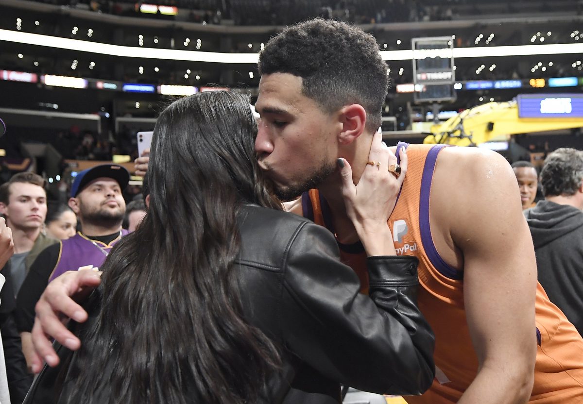 Devin Booker ne semble pas croire à la malédiction Kardashian-Jenner alors qu'il embrasse et étreint Kendall Jenner après un match des Suns