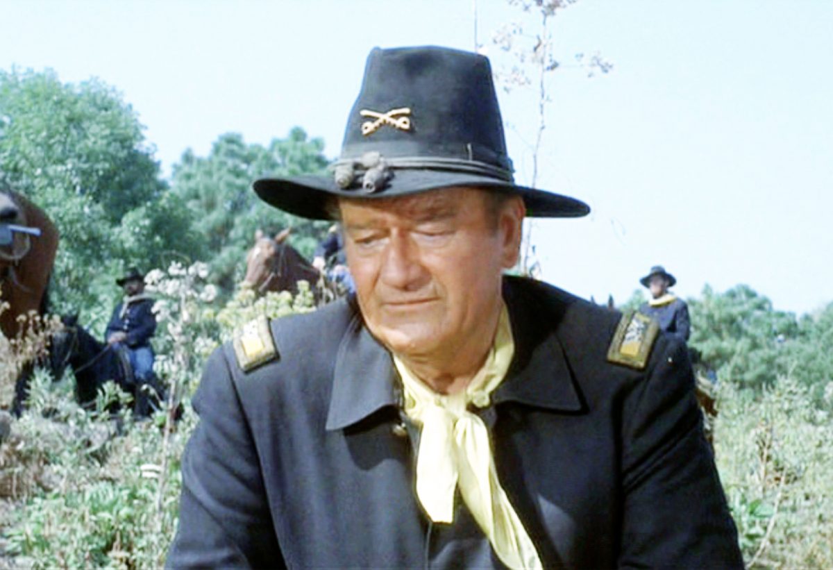 John Wayne dans le rôle du colonel Cord McNally dans 'Rio Lobo' dans une tenue de cow-boy regardant le sol, dont la vraie mère était Mary 'Molly' Alberta Brown