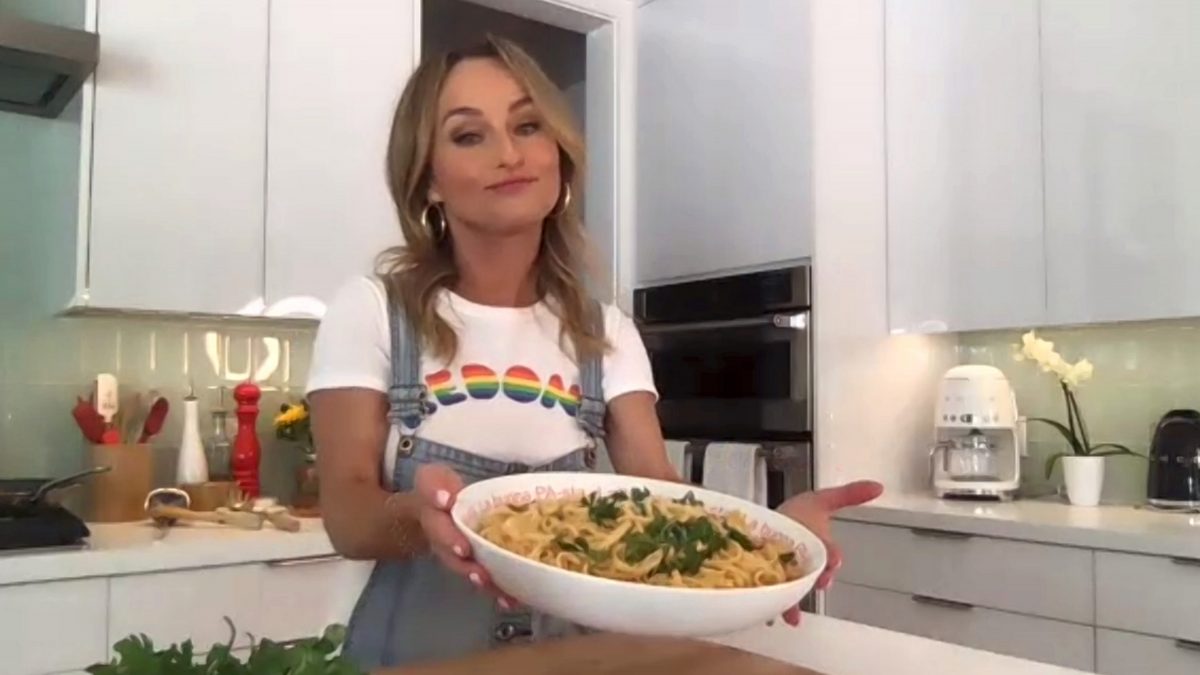 La star de Food Network, Giada De Laurentiis, tient un bol de pâtes et de légumes verts sur cette photo.