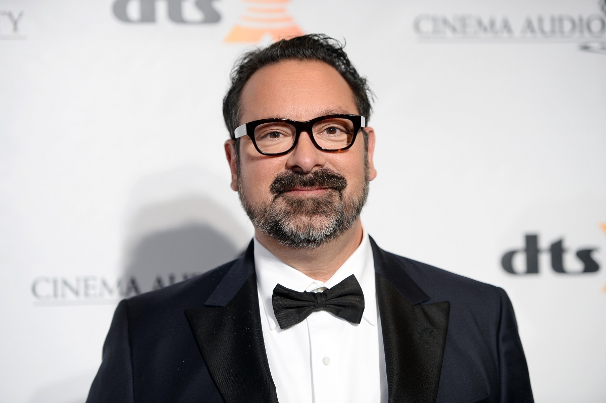 James Mangold souriant tout en portant un costume et des lunettes.