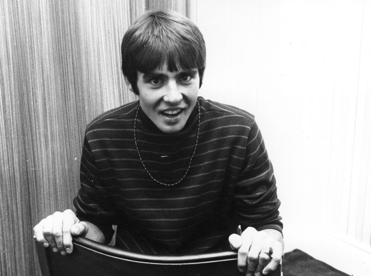 Davy Jones des Monkees devant un rideau