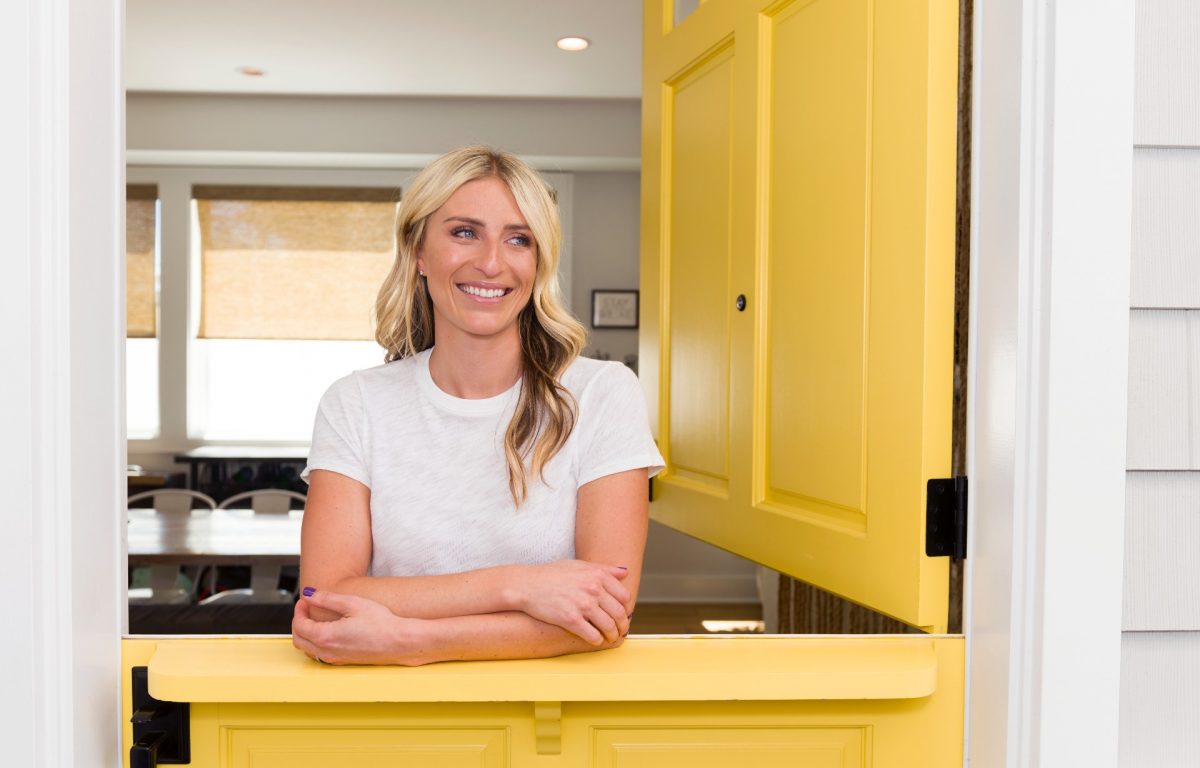 Jasmine Roth se tient dans une pièce jaune.