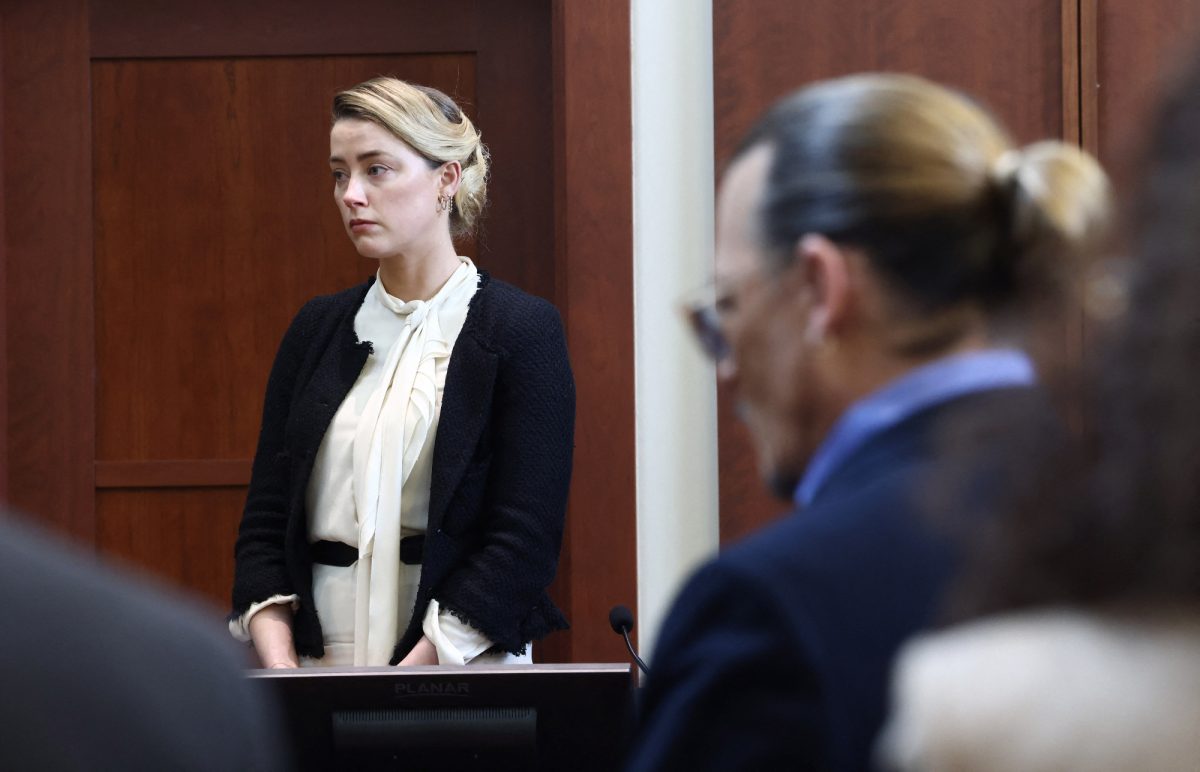 Amber Heard et Johnny Depp au tribunal pour témoigner devant le jury afin de déterminer un gagnant dans l'affaire de diffamation.  Heard regarde sur le côté et Depp est au premier plan avec des lunettes de soleil.