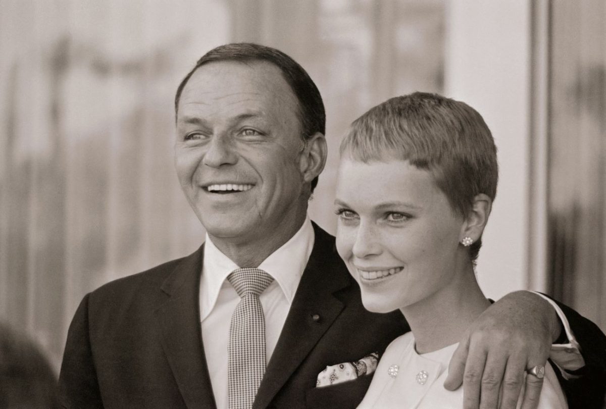 Une photo en noir et blanc de Frank Sinatra debout avec sa main autour des épaules de Mia Farrow.