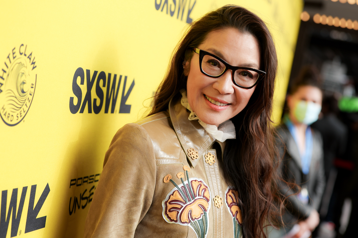 Michelle Yeoh porte des lunettes et sourit sur le tapis rouge