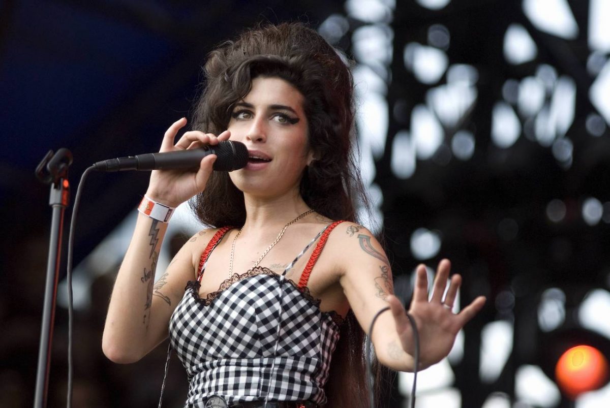 Amy Winehouse se produisant dans une robe blanche et noire en 2007.