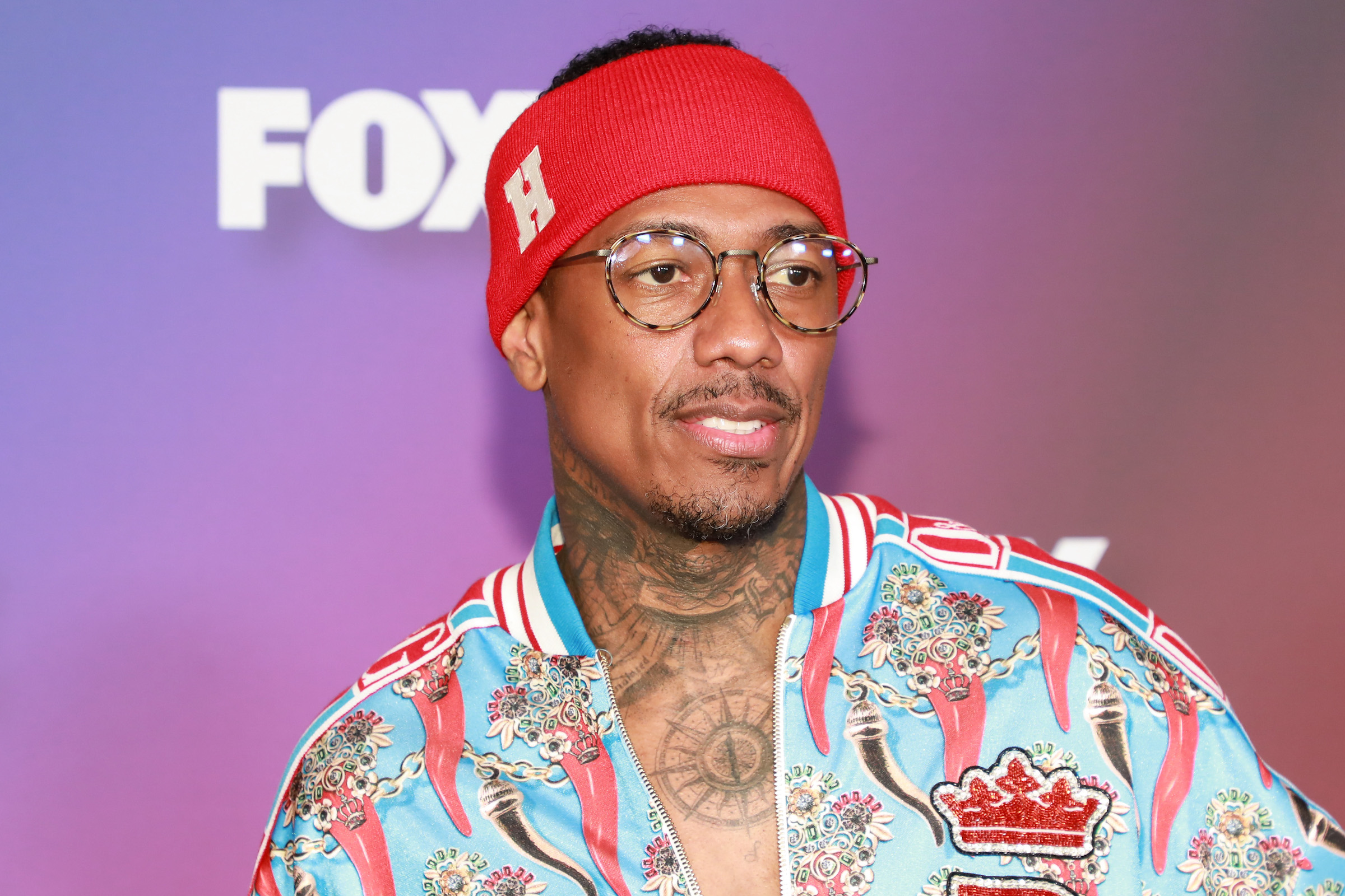 Nick Cannon portant un bandeau rouge et une chemise bleue
