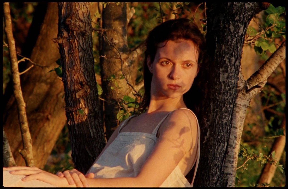 Juliette Jouan dans le rôle de Juliette allongée contre un arbre dans une robe blanche dans 'Scarlet'