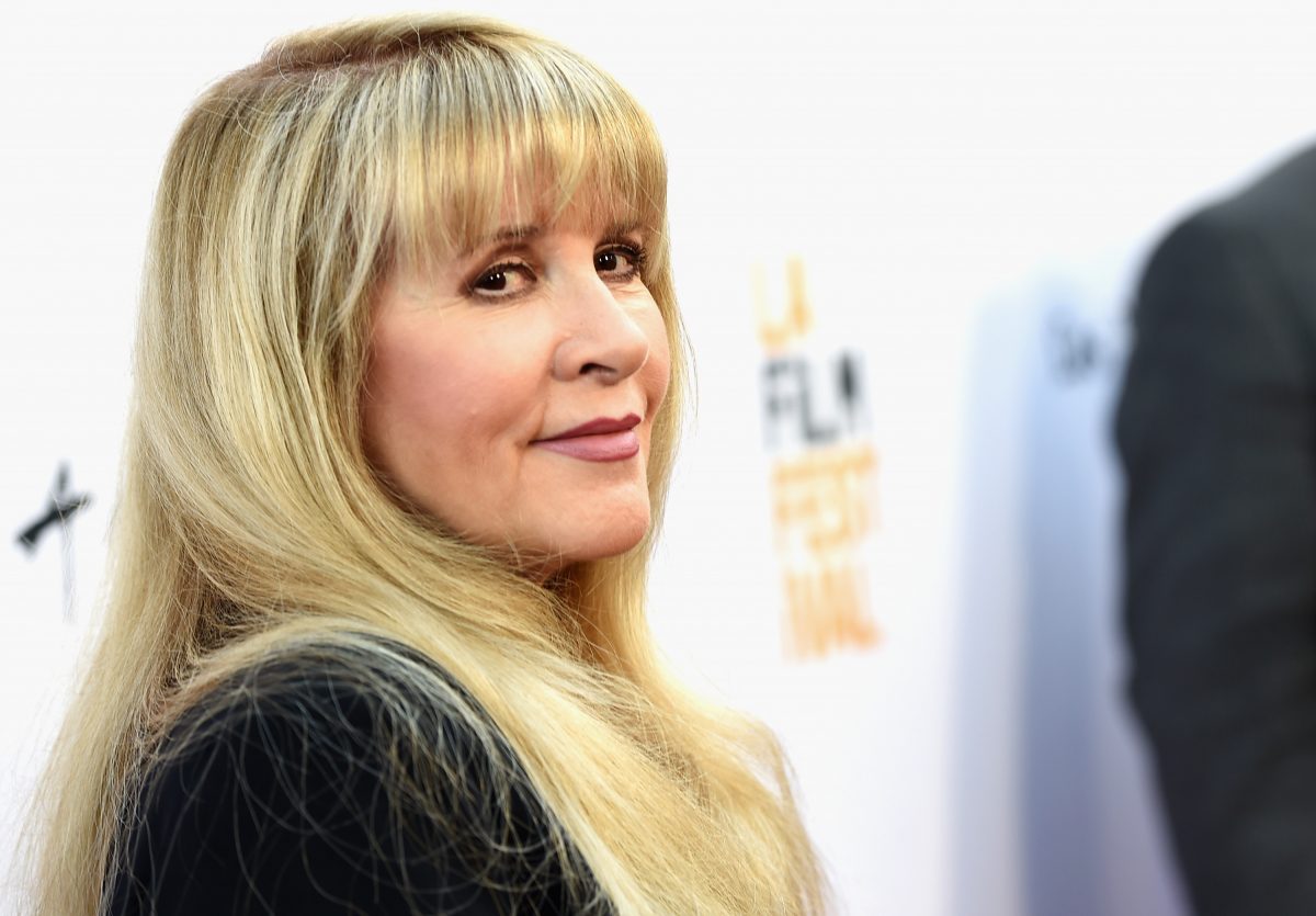 Stevie Nicks porte une tenue noire sur fond blanc.