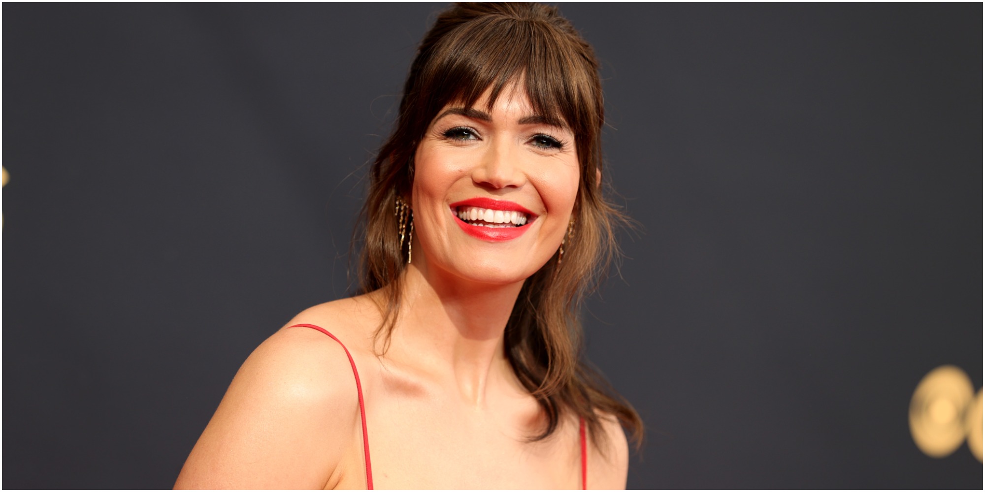 Mandy Moore porte une robe rouge sur le tapis rouge des Emmy Awards 2021.