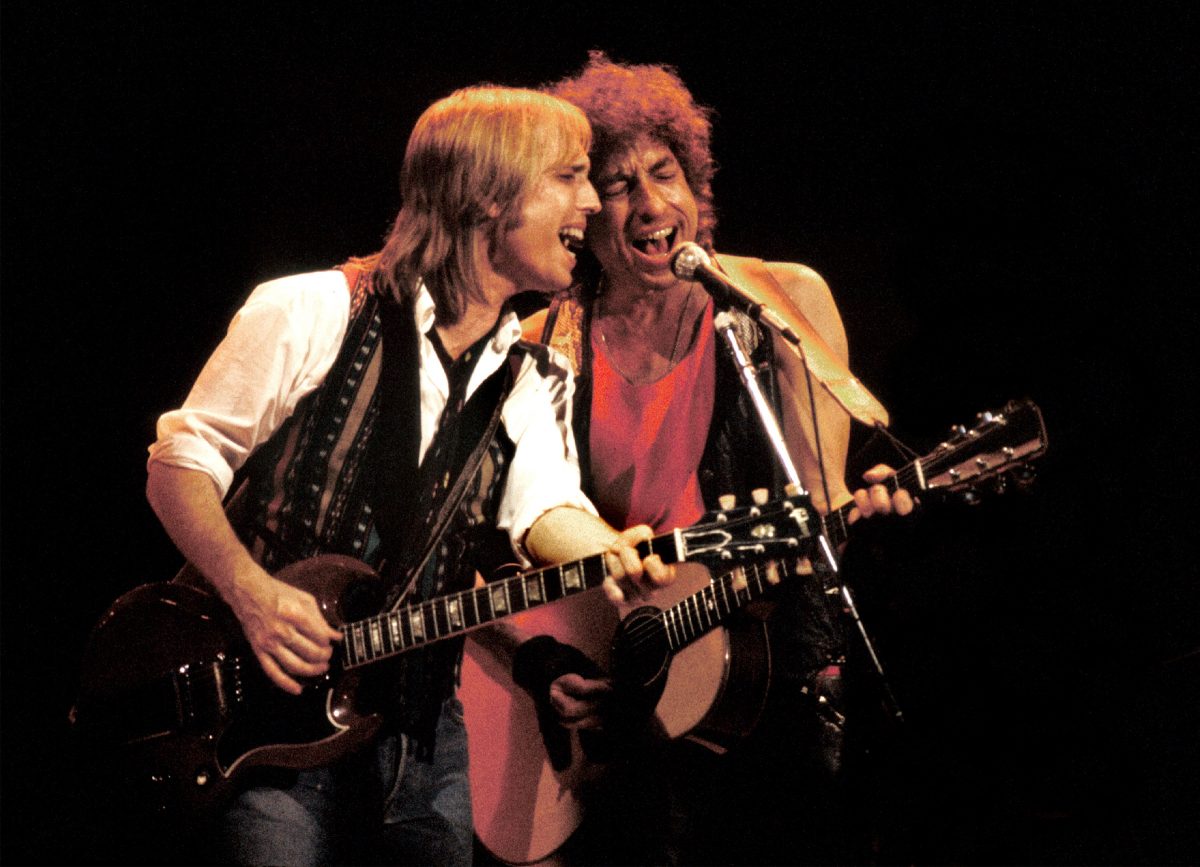 Tom Petty et Bob Dylan jouent de la guitare et chantent dans le même micro.
