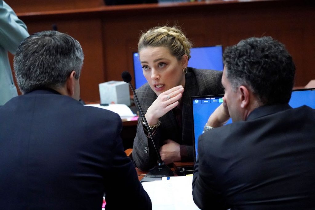 Amber Heard parle à son avocat dans la salle d'audience pendant une pause