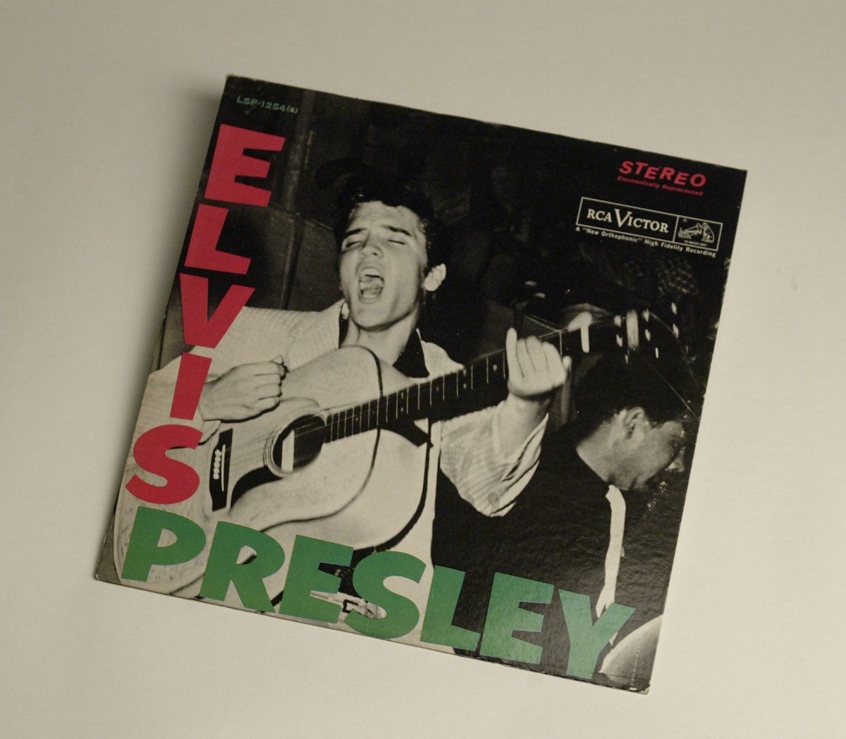 Elvis Presley chantant une chanson sur la couverture de son premier album