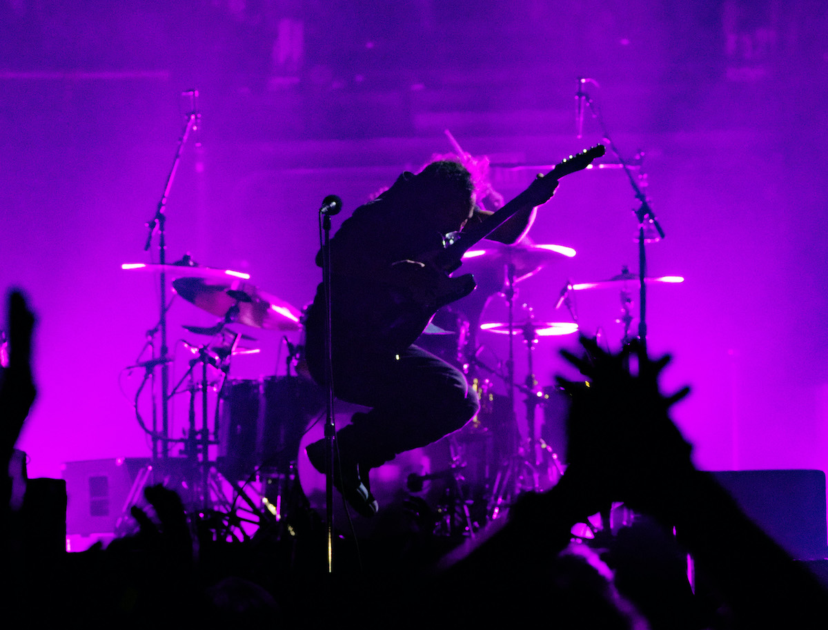 Eddie Vedder de Pearl Jam sautant en jouant