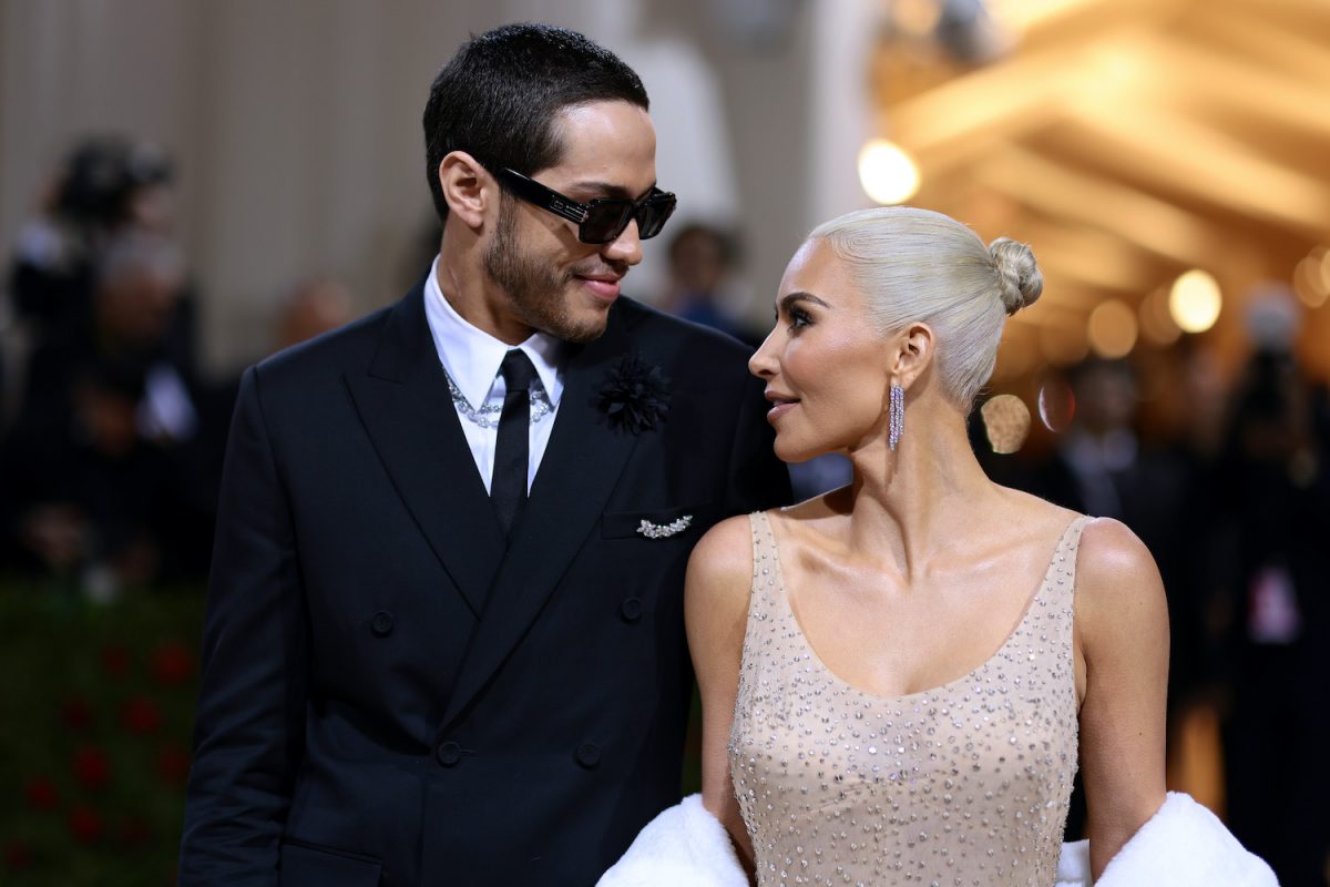 Kim Kardashian porte une robe nude à paillettes et Pete Davidson est vêtu d'un costume noir alors qu'ils se regardent au Met Gala 2022
