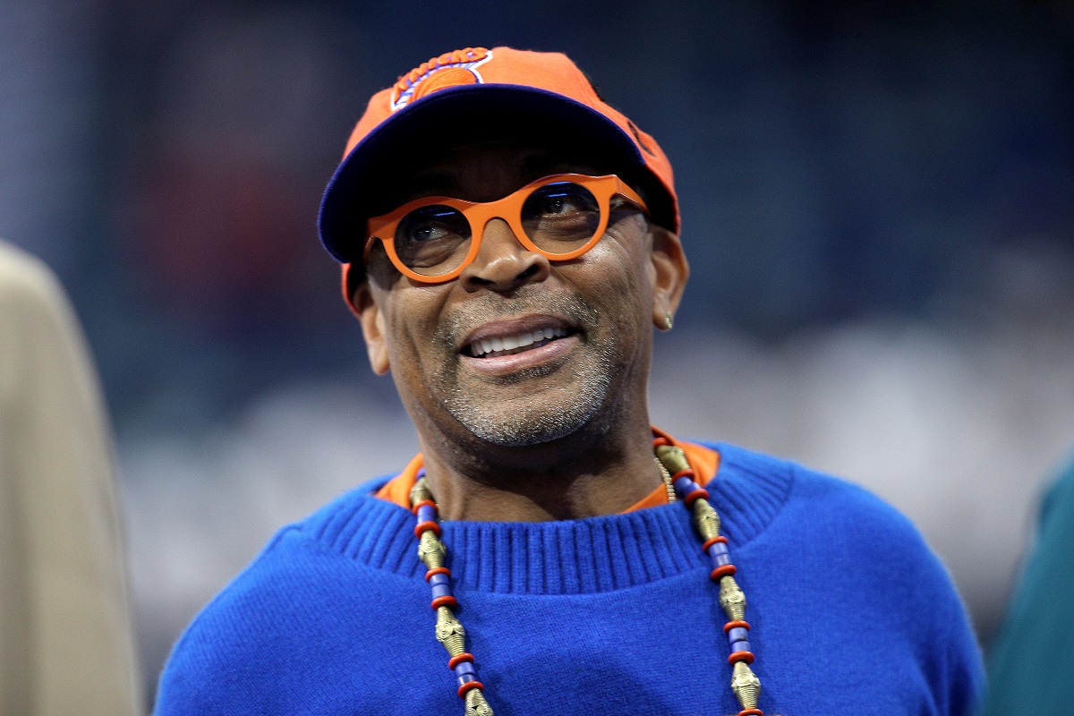 Spike Lee souriant tout en portant une casquette orange.