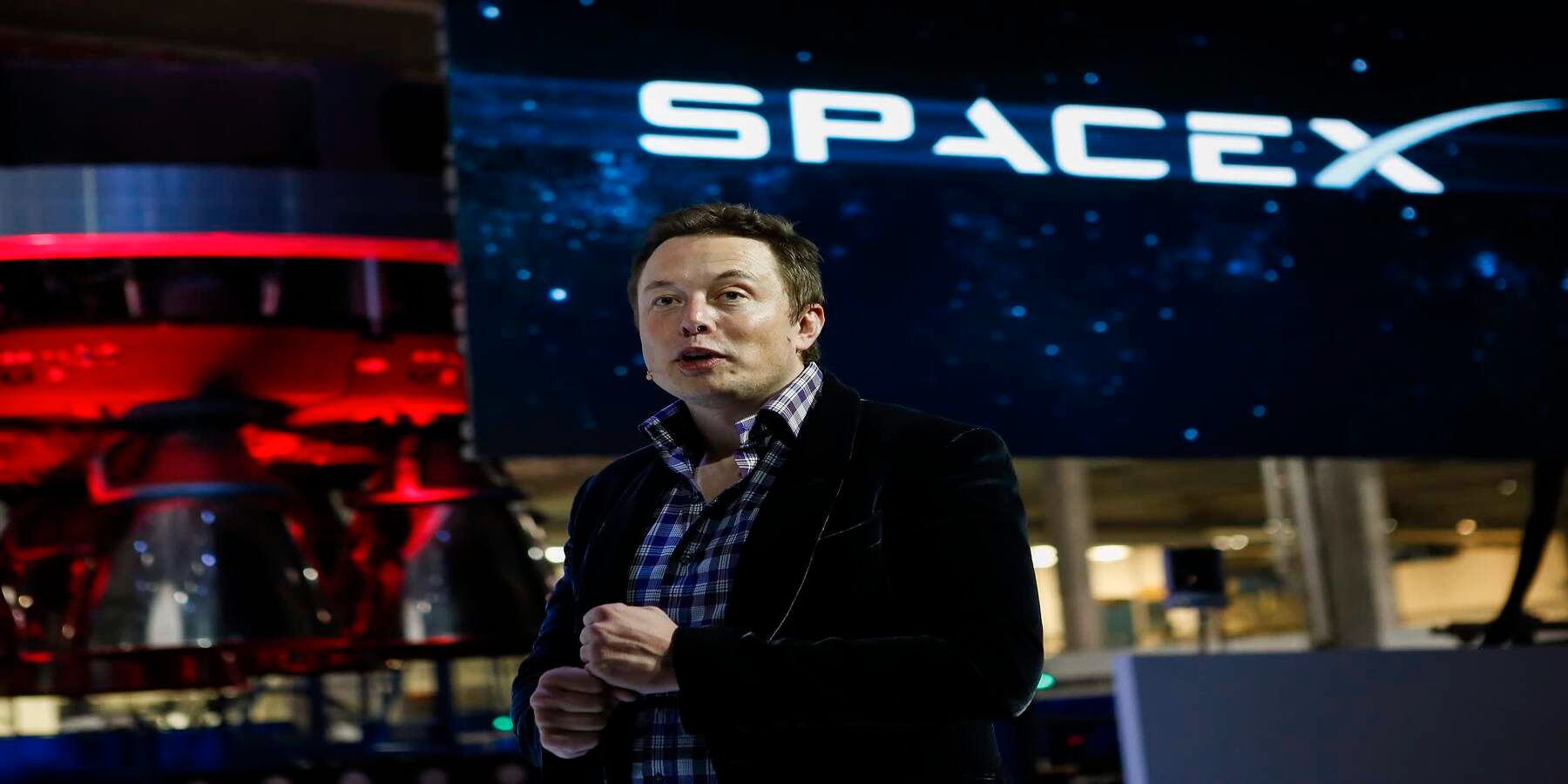 Elon Musk devant le logo SpaceX