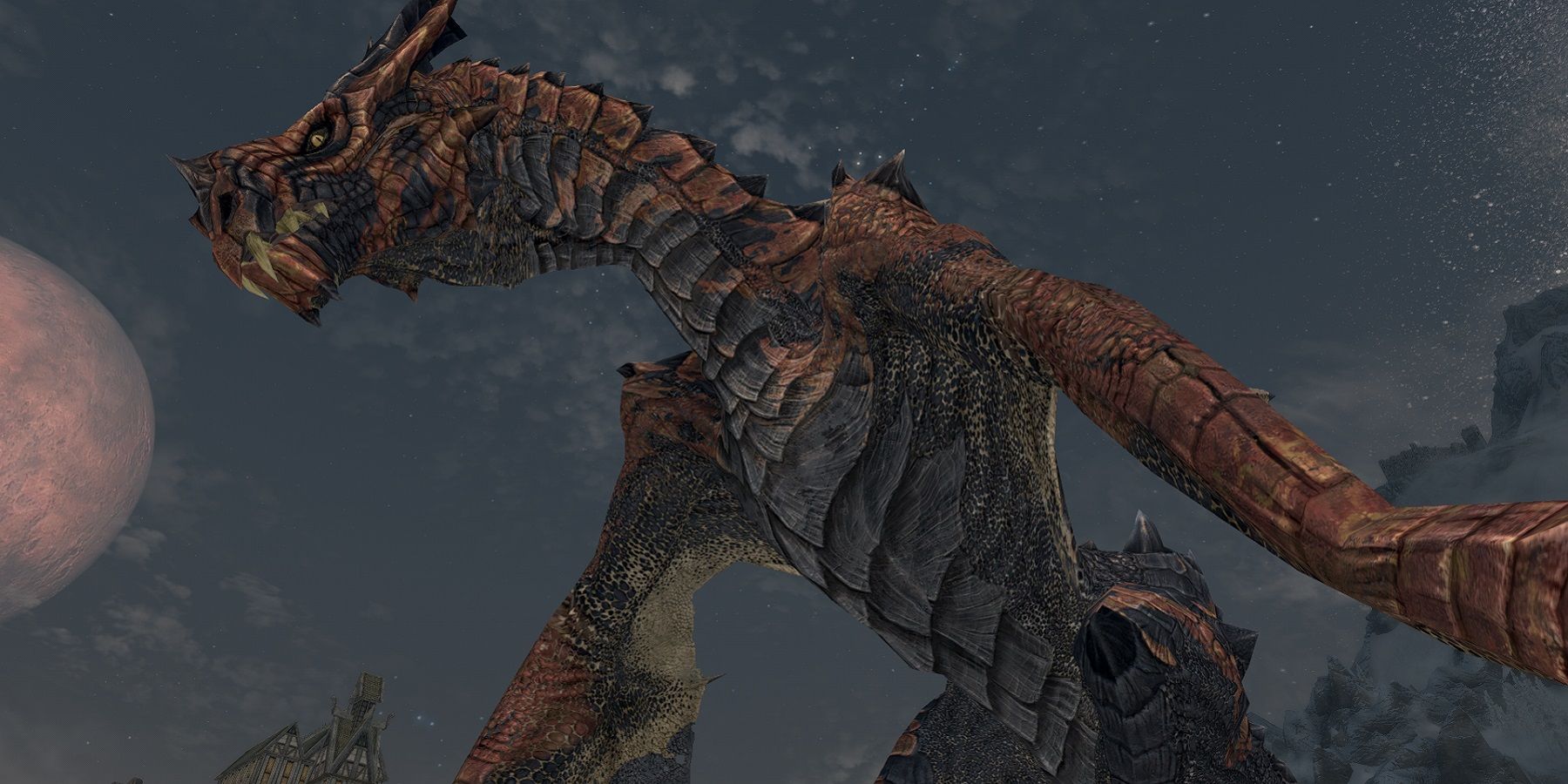 Image de Skyrim montrant le dessous d'un dragon la nuit.